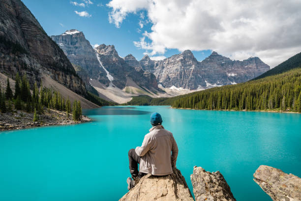 Hiker at Moraine Lake in Banff National Park, Alberta, Canada Hiker at Moraine Lake during summer in Banff National Park, Alberta, Canada. banff national park photos stock pictures, royalty-free photos & images