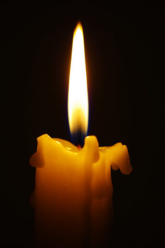 Close-up of burning candle in the dark