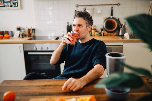 istock man having a fruit smoothie for breakfast at his home 1303908205