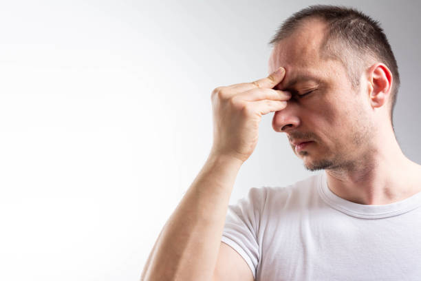 istock man suffering from headache, migraine or hangover 1303908219