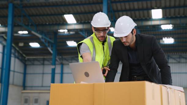 istock Two factory workers working and discussing manufacturing plan in the factory . 1303908254
