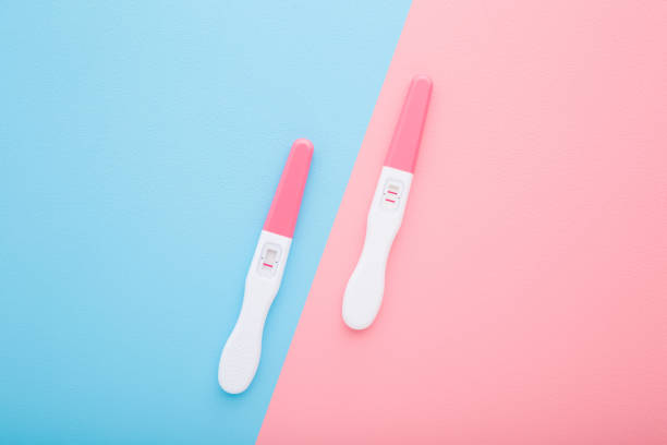 тесты на беременность с одной полосой и двумя полосами на светло-голубом розовом фоне стола. пастельные цвета. отрицательный и положительн� - pregnancy test стоковые фото и изображения