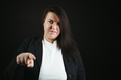Confident woman pointing finger looking at camera. Choice, encourage, motivation concept