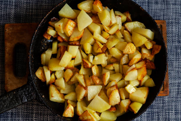istock Pan fried potatoes on a wooden cutting board. 1303911373