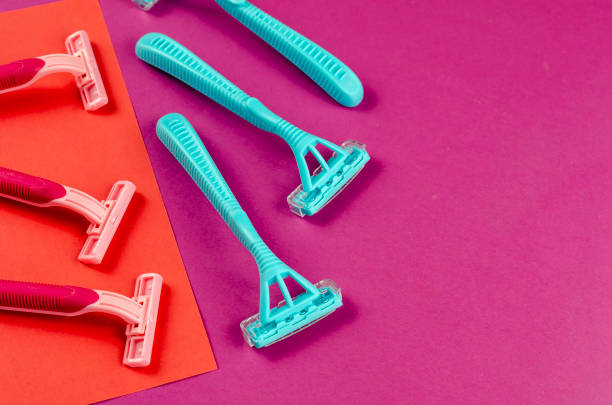 istock Three pink plastic razors against blue ones on a red-pink background. 1303911390