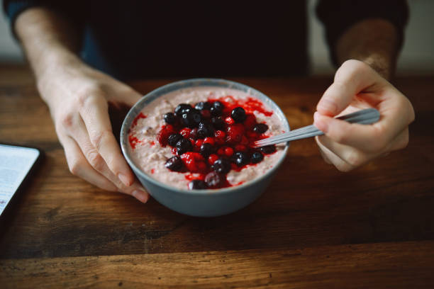 istock young man having an oatmeal with forest fruits 1303912245