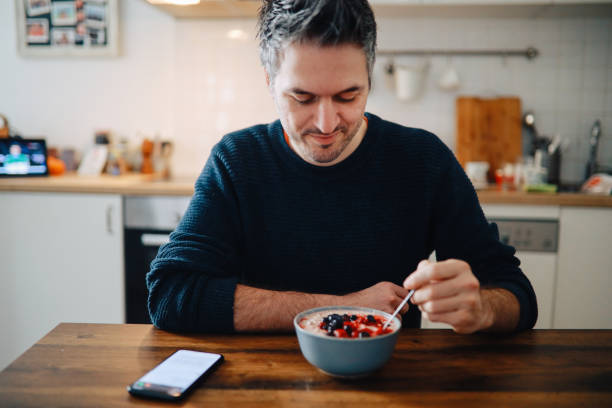 istock young man having an oatmeal with forest fruits 1303912279