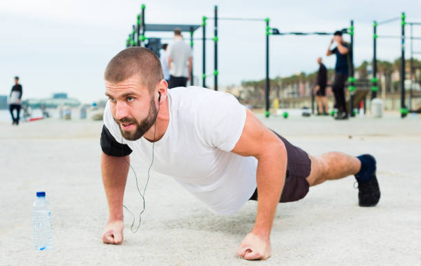 istock man performs push-ups on sportsground 1303912435