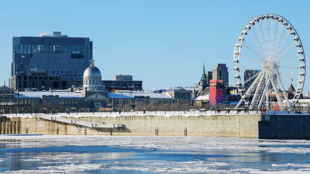 istock Old Montreal Ferris wheel and docks on a clear Winter day 1303912990