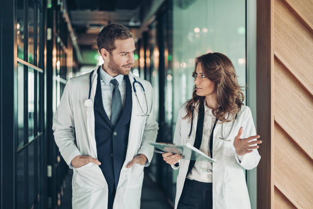 istock Couple of doctors walking side by side and talking 1303915056