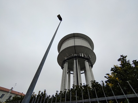 A water tower is an elevated building supporting a water tank constructed at a height sufficient to pressurize a water distribution system for the distribution of potable water, and to provide emergency storage for fire protection