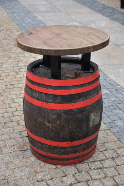 istock Wooden table on barrel with red hoops on street 1303918237