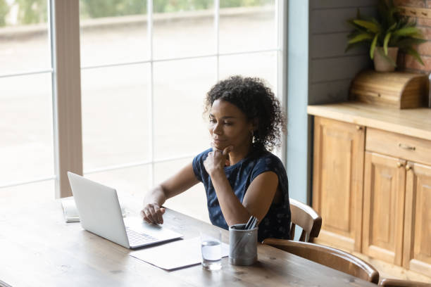 istock Top view satisfied thoughtful African American woman using laptop 1303920879