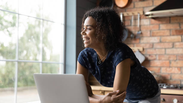 istock Close up overjoyed dreamy African American woman using laptop 1303920908