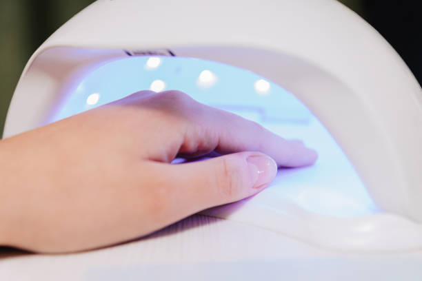 istock Manicure process. Drying nails in a device with ultraviolet lamps. 1303922126