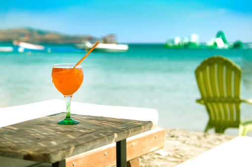 Orange cocktail in glass on the beach club at the seaside. Summer vocation.