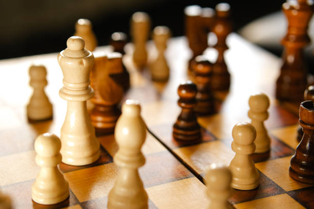보드에 흰색과 갈색 나무 체스 조각. - chess defending chess piece chess board 뉴스 사진 이미지