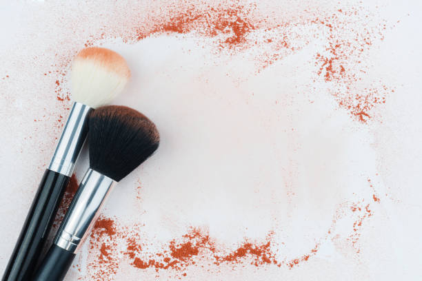 istock Makeup brushes on background with colorful powder. Make-up background 1303922373