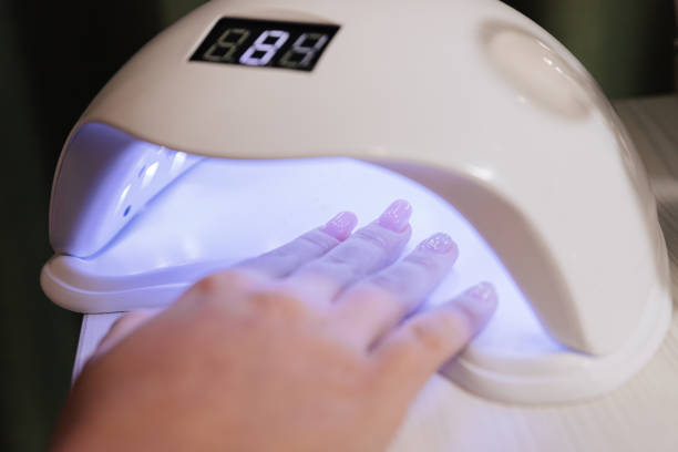 istock Manicure process. Drying nails in a device with ultraviolet lamps. 1303922404