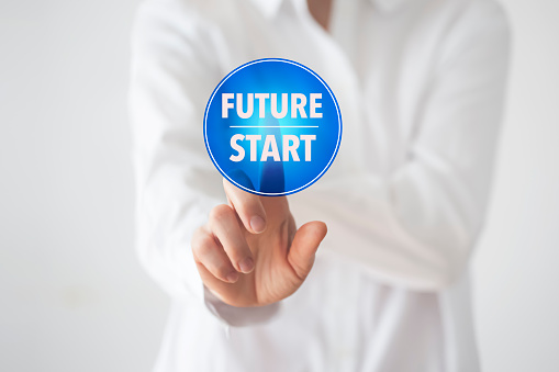 Businesswoman  pressing blue”Future Start “button on the white board.  Strategic Vision.