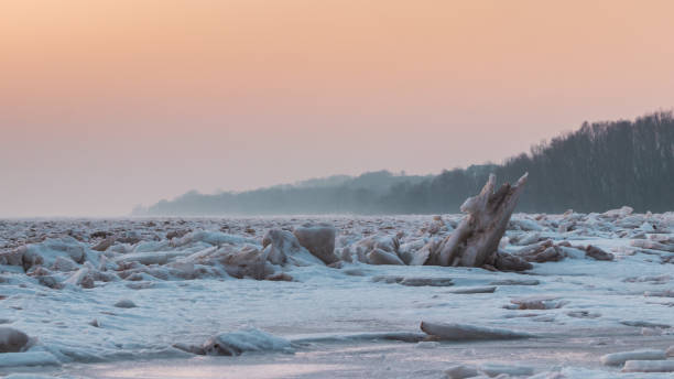vista do pôr do sol e blocos de gelo quebrados no rio vístula na cidade de plock na polônia - ice floe - fotografias e filmes do acervo