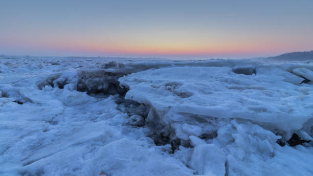 vista do pôr do sol e blocos de gelo quebrados no rio vístula na cidade de plock na polônia - ice floe - fotografias e filmes do acervo