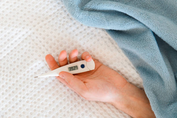 istock man hand holding a digital thermometer 1303925362