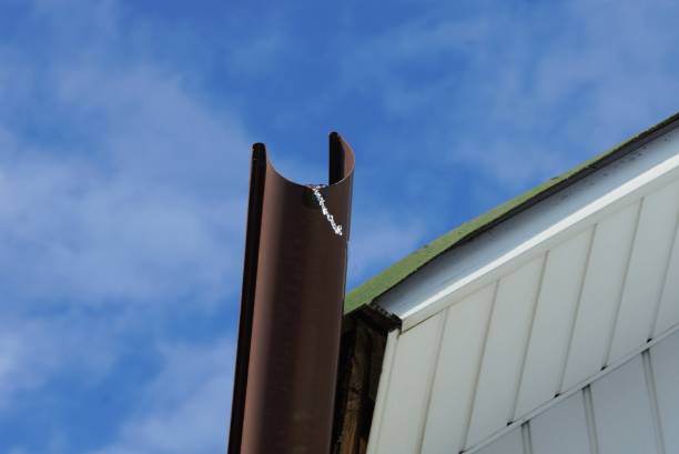 istock one brown plastic gutter pipe on a white roof of a house 1303925421