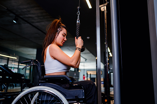 Adaptive athlete in a wheelchair lifting weight