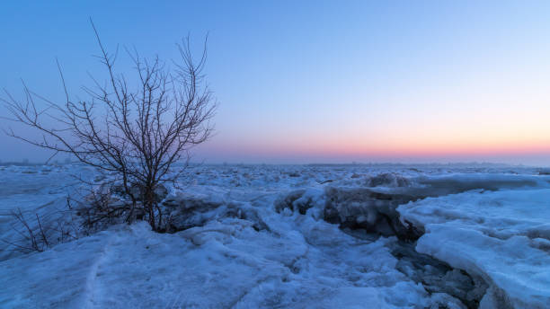 vista do pôr do sol e blocos de gelo quebrados no rio vístula na cidade de plock na polônia - ice floe - fotografias e filmes do acervo