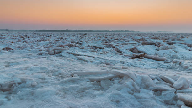 view of the sunset and broken ice floes on the vistula river in the city of plock in poland - floe lake imagens e fotografias de stock