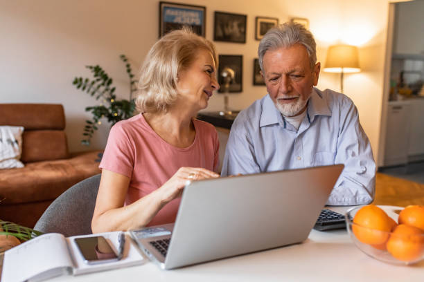 istock Senior couple at home, using laptop 1303926676