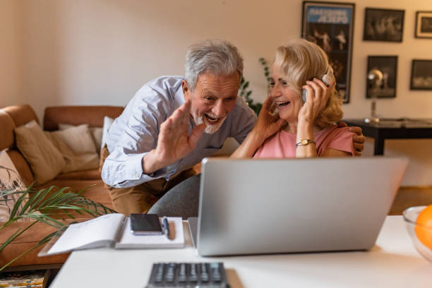 istock Happy senior couple at home, using laptop 1303927286