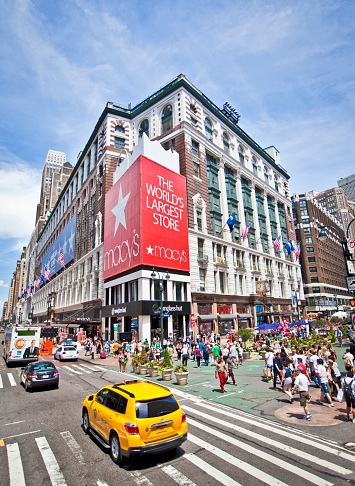 New York, NY, USA - June 11, 2022: Macy's Herald Square, with a W 34 St street sign in the foreground.