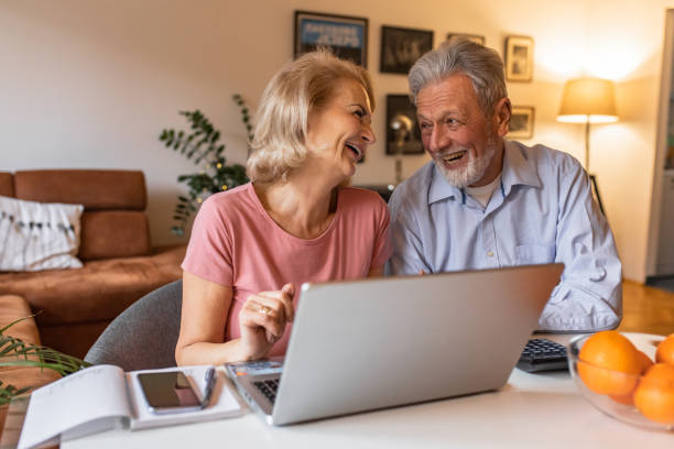 istock Happy senior couple at home, using laptop 1303927389