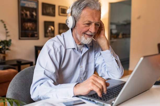istock Senior man at home, sitting at the desk and using laptop 1303927594
