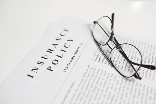 istock insurance policy contract with spectacles on white table. Close up view 1303927764