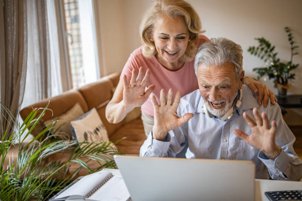 istock Happy senior couple at home, using laptop 1303928448