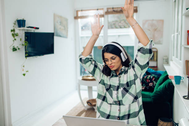 istock Young woman dancing and enjoying music after work 1303928857