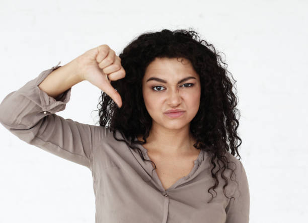 istock African American young woman expresses her negativity, points down and expresses her protest 1303931729