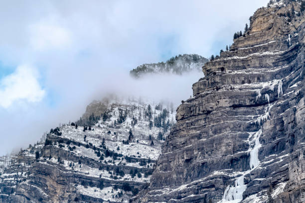Scenic Provo Canyon scenery with Bridal Veil Falls under sky with thick clouds. The beautiful waterfall is frozen on this cold winter day.