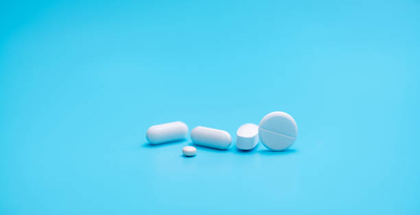 Round white tablets pills on blue background. Tablets and caplets pills pharmaceutical dosage form. Pharmacy and health topics background. Pharmaceutical industry banner. Online pharmacy store banner. píldoras redondas de comprimidos blancos sobre fondo azul. tabletas y caplets píldoras forma de dosificación farmacéutica. antecedentes de temas de farmacia y salud. bandera de la industria farmacéutica. banner de la tienda de farmacia en línea.