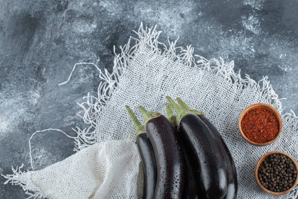 istock Fresh organic purple eggplants with spices, red and black pepper 1303948774