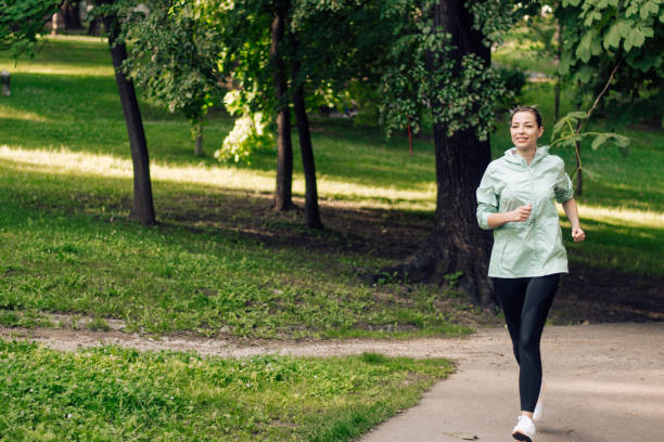 istock Happy young woman jogging 1303952336