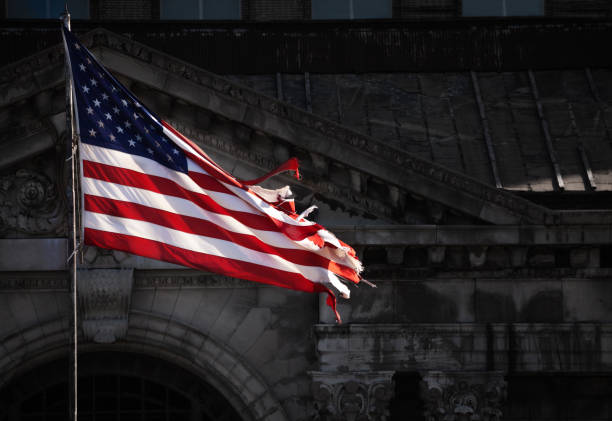 istock Faded USA flag in front of abandoned building 1303952820