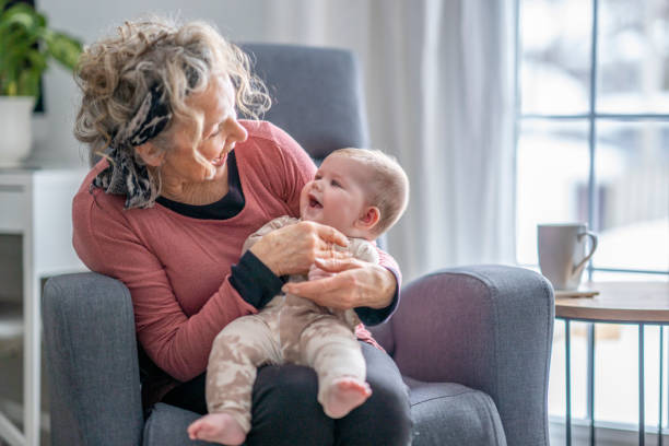 Grandmother with grandchild A beautiful grandma spending quality with her 5 month old granddaughter. grandmother stock pictures, royalty-free photos & images