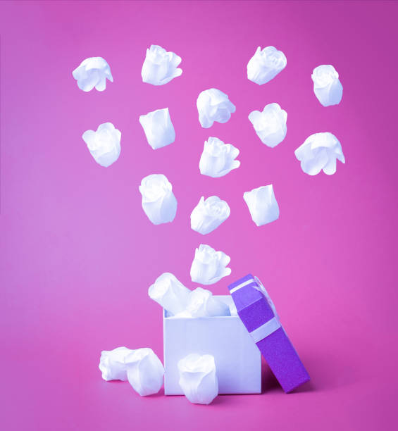 istock White heart-shaped rose buds fly out of the gift box. 1303957590