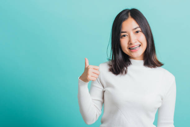 istock woman cheerful smiling showing finger thumb up 1303959208