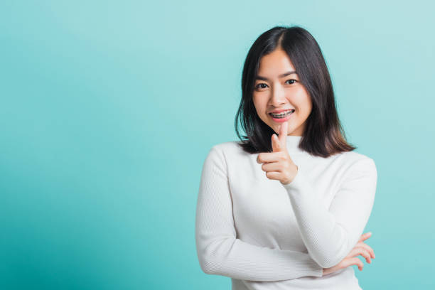 istock woman smiling point finger at you 1303959231