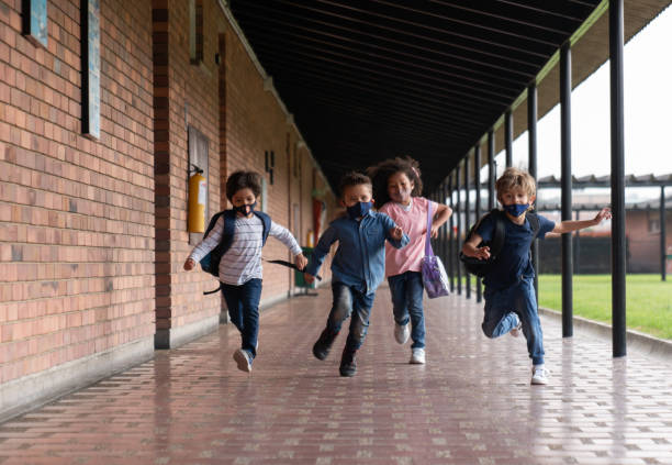 Children running at the school while wearing facemasks